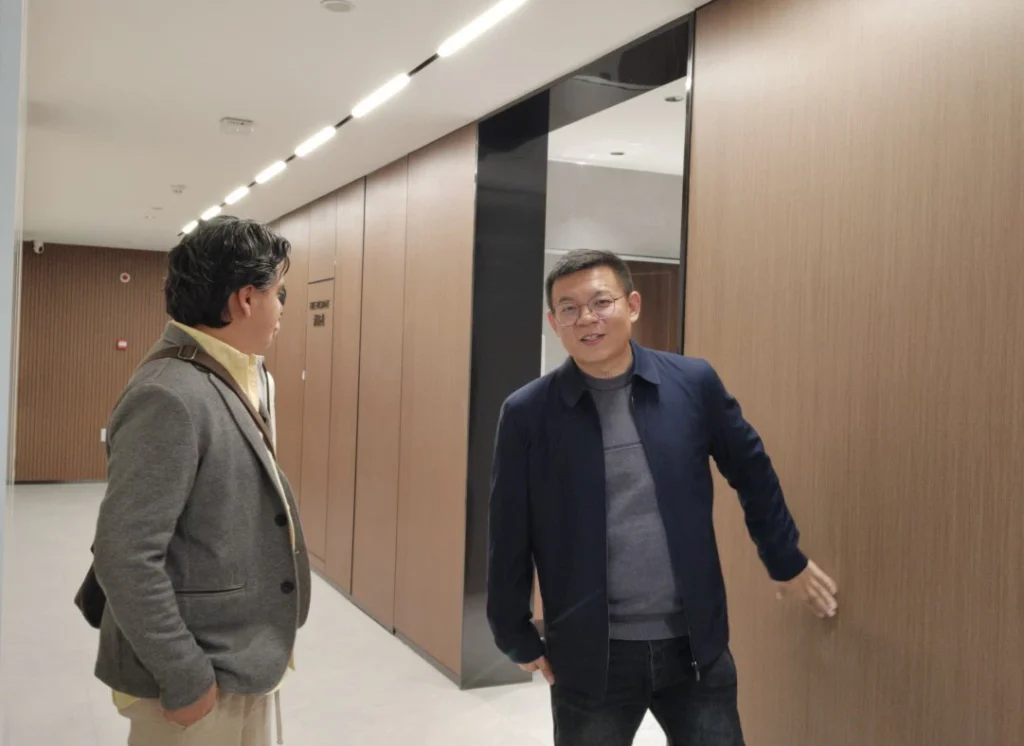 Business colleagues touring a modern office corridor during a professional building walkthrough.