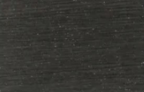 Dark brushed metal surface with subtle horizontal grain and light speckles