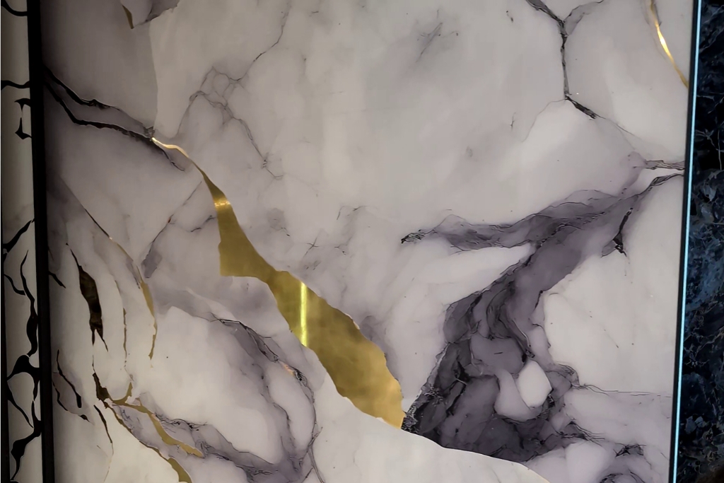 Kintsugi-inspired white marble panel with gray veining and gold crack accents