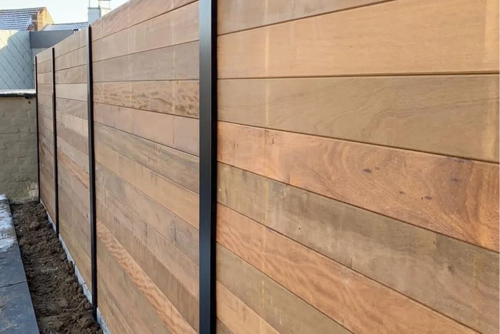 Modern horizontal wood fence with black metal posts, offering privacy and contemporary style.