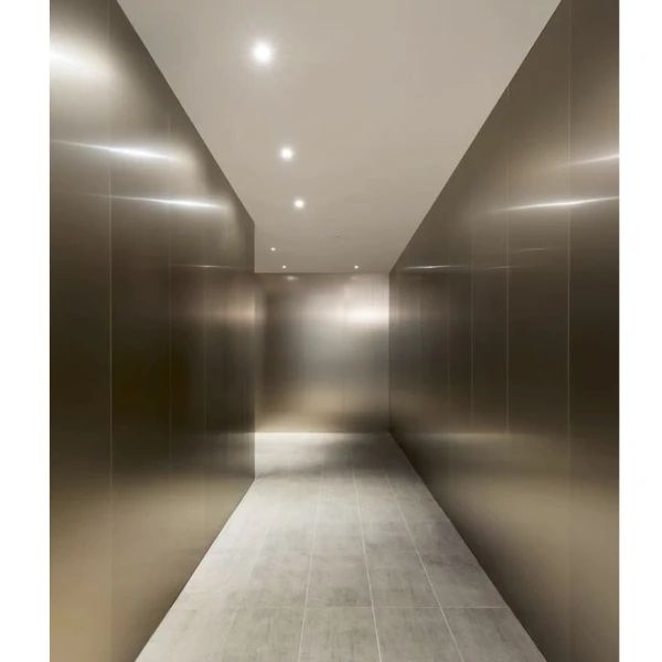 Minimalist metallic hallway with brushed steel walls and recessed ceiling lights