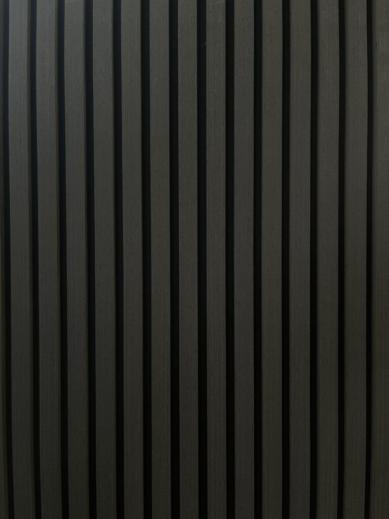 Minimalist dark background with evenly spaced vertical black stripes and subtle reflective texture