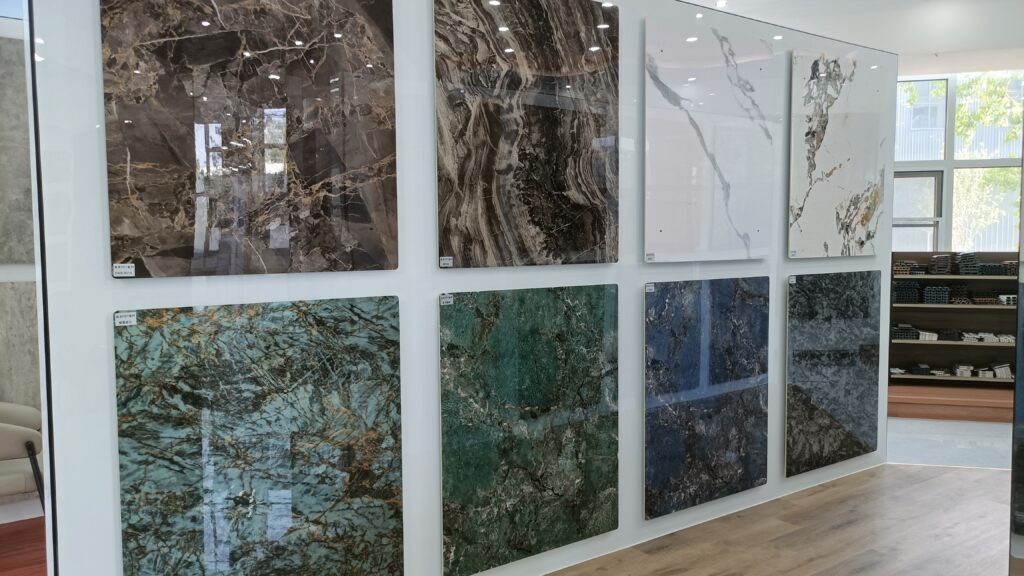 Modern showroom wall displaying eight marble and stone slabs in varied colors and patterns