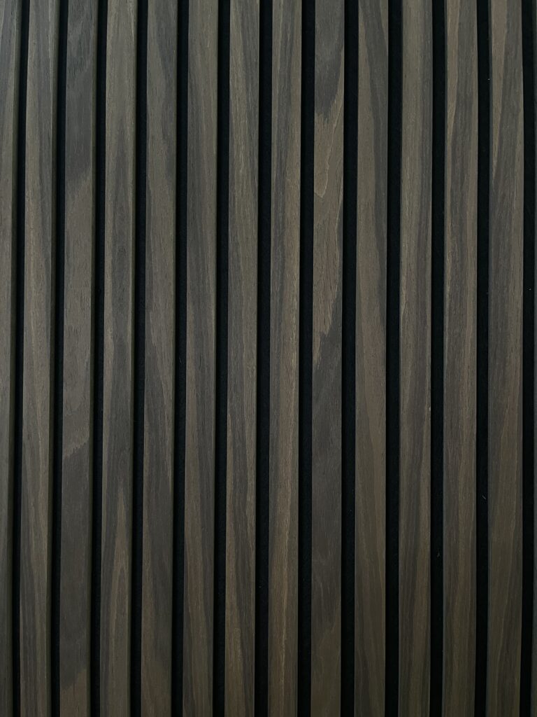 Modern vertical wood slat wall paneling with alternating dark and light brown stripes