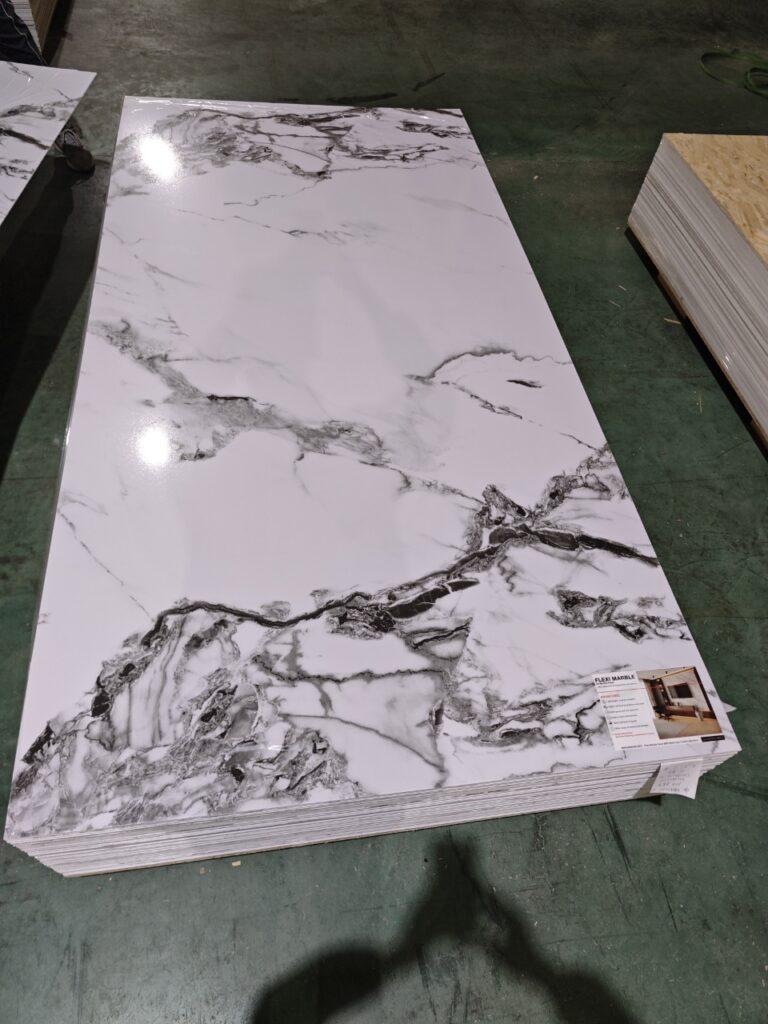 Polished white marble slab with dramatic gray veining in industrial warehouse