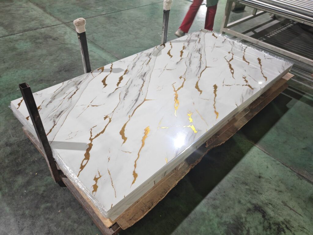 Polished white quartz slab with gold veining on pallet in warehouse
