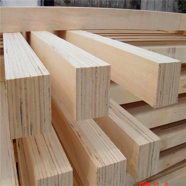 Stacked laminated veneer lumber beams with visible layered edges in a warehouse