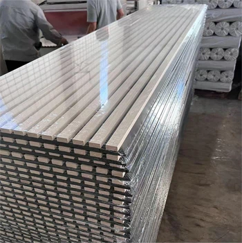 Shrink-wrapped stacked metal panels in a manufacturing facility warehouse