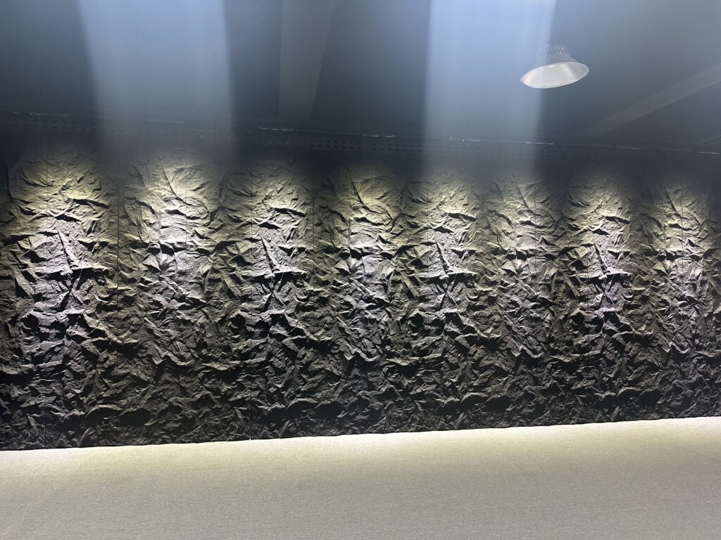 Dramatically lit textured stone wall in modern interior with smooth floor