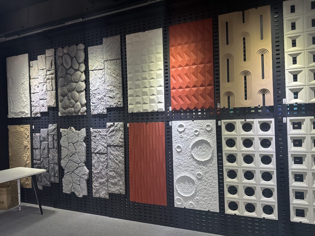 Modern showroom display of textured decorative wall panels with stone, geometric, and sculptural designs