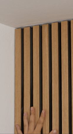 Modern vertical wood slat wall corner with hand touching minimalist interior paneling
