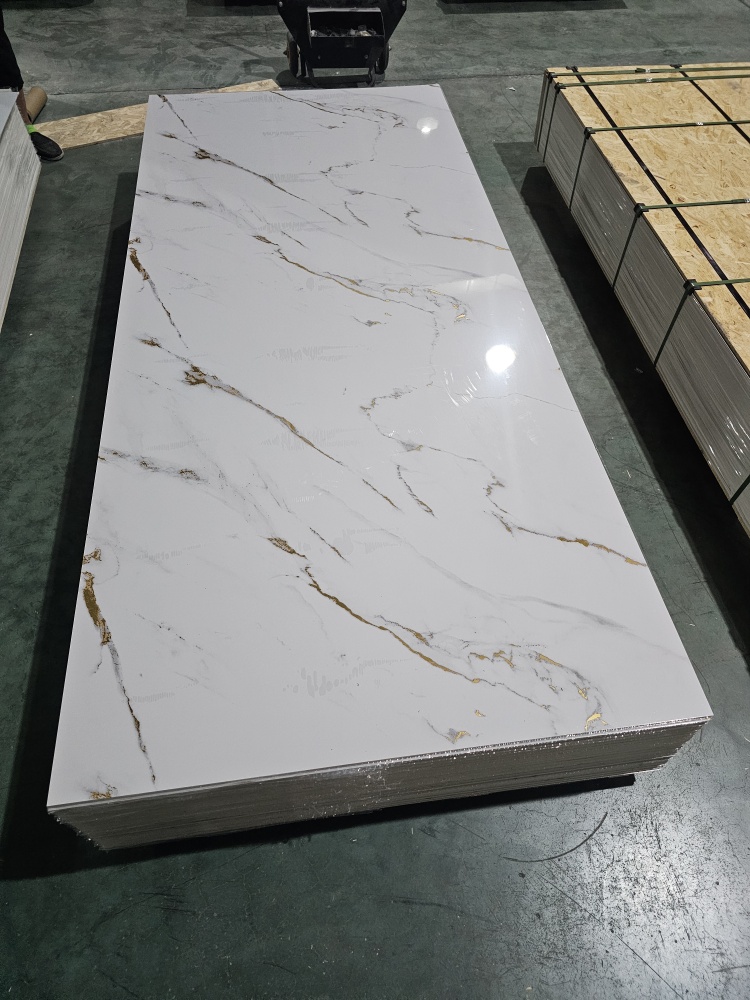 Polished Calacatta-style white quartz slab with gray and gold veining in factory.