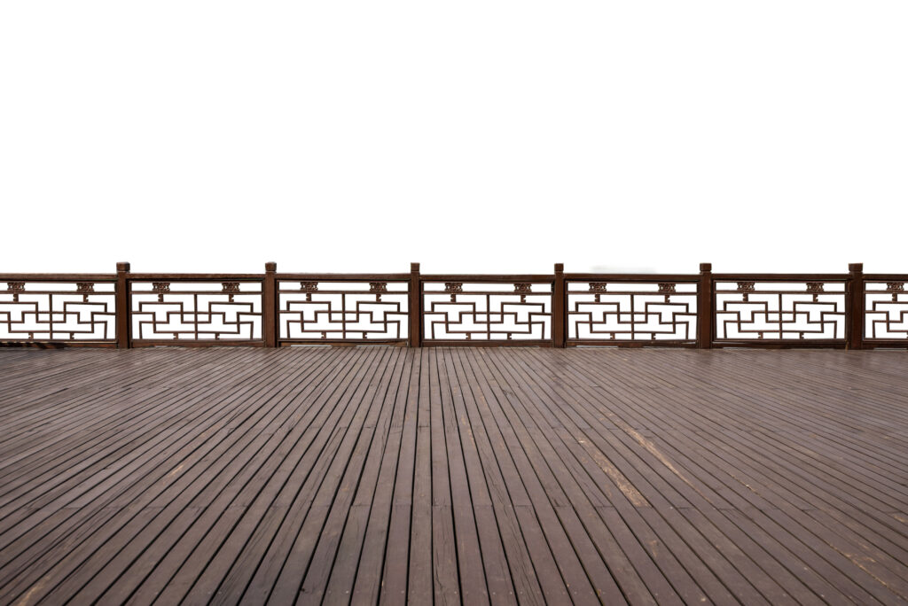 Empty wooden pavilion deck with ornate railing and minimalist white background